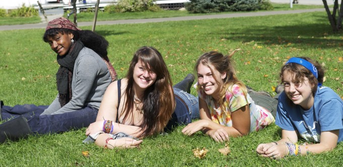 Four girls smiling together on a lawn